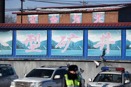 12月17日，一名警察在发生事故的鹤岗市向阳煤矿的办公区执勤。记者17日9时从黑龙江省鹤岗市向阳煤矿矿难前方指挥部初步核实确认，爆炸事故发生前井下共有52名矿工，截至目前共有33名矿工顺利升井，仍有19人被困井下。12月16日14时30分许，向阳煤矿发生瓦斯爆炸事故。新华社记者 王建威 摄