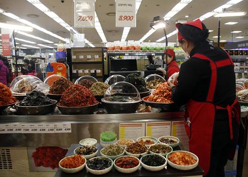 12月20日，在韩国首尔一家大型超市，店员在推销韩国泡菜。中国-韩国自贸协定20日正式生效。韩国是中国重要贸易伙伴，中韩自贸区的建成将给中国对外经贸关系乃至亚太地区的经贸深度融合带来巨大推动力。分析人士称，随着中韩自贸协定生效，中国消费者可买到更质优价廉的韩国商品，无需出国便可享受韩国整形服务，赴韩旅游更容易，能吃到正宗韩国泡菜等。而物美价廉的“中国制造”也将进入韩国百姓的日常生活。此外，韩国的化妆品、娱乐等产业也将迎来重大利好。