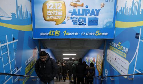 12月19日，在韩国首尔，人们经过中文的支付宝广告。