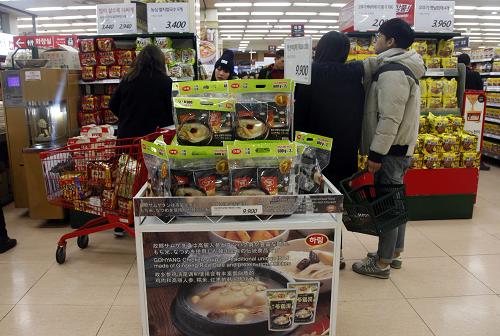 12月20日，在韩国首尔一家大型超市，人们在选购参鸡汤等韩国产品。