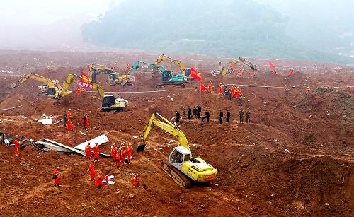 12月21日，武警水电部队官兵在深圳山体滑坡现场开展救援（手机拍摄）。当日，武警水电部队首批救援官兵和大型救援设备抵达广东深圳市光明新区山体滑坡救援现场，开始抢通通往滑坡体核心区域的生命通道。据通报，目前失联91人，其中59名男性，32名女性。新华社发（王国华 摄）