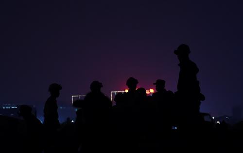 12月21日，在发现生命迹象的二手车市场，救援人员在搜寻生存者。截至12月21日晚23时40分，深圳市光明新区滑坡灾害36小时最佳救援时间已经过去，救援人员依然没有放弃搜救工作。