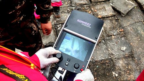 12月22日，在深圳光明新区滑坡灾害救援现场，武警水电部队官兵利用“蛇眼生命探测仪”对任务区进行搜救（手机拍摄）。新华社发（谭明裕 摄）