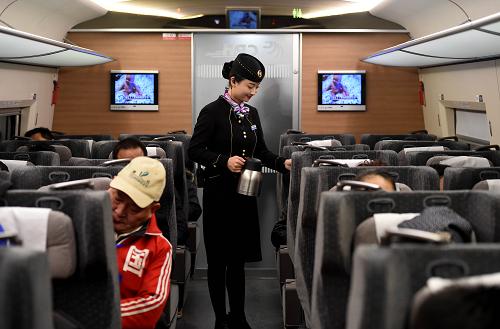 12月22日，郑机城际铁路乘务员在旅途中为试乘乘客服务。新华社记者 李安 摄