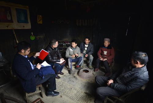 12月22日，湖北省宣恩县县办公室“扶贫家长”谭发军（左二）在椒园镇石马村贫困农民曾福清（右三）家走访。新华社发（宋文 摄）