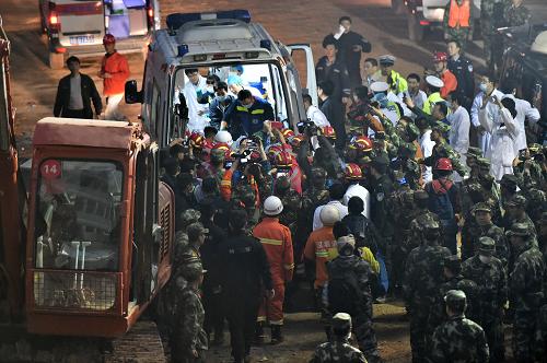 12月23日，深圳滑坡事故第一名幸存者被抬至救护车。