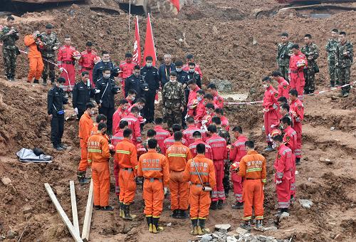 12月23日，救援人员向已无生命体征的被困者脱帽致哀。