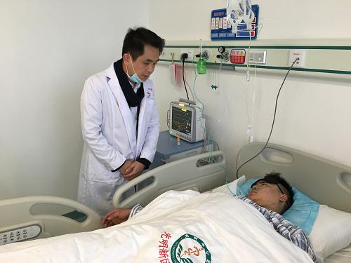12月23日，在深圳光明新区中心医院，田泽明接受老乡看望。当日，深圳滑坡事故首名被发现的幸存者田泽明在深圳光明新区中心医院接受手术后已经清醒，目前生命体征稳定。新华社发