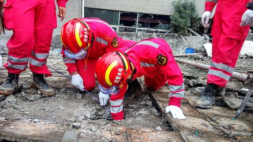 12月22日，在深圳光明新区滑坡灾害救援现场，救援人员利用“蛇眼生命探测仪”对任务区进行搜救（手机拍摄）。