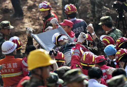 12月23日6时许，幸存者田泽明被抬出滑坡现场，送往救护车停靠点。