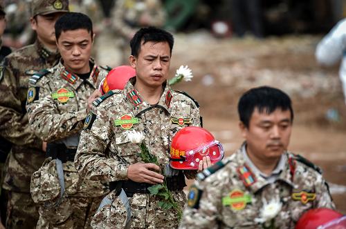 12月26日，来自深圳智慧海安全救援服务中心应急分队的救援人员在哀悼仪式上向遇难者献花。