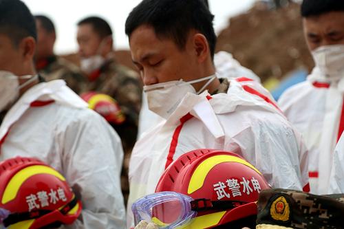12月26日，参与救援的武警水电部队官兵为深圳滑坡事故遇难者默哀。