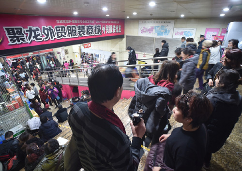 12月29日，市民在即将疏解闭市的聚龙外贸服装商城扫货。为有序疏解北京非首都功能，位于北京西城区“动批”商圈的第一家地下服装批发市场——聚龙外贸服装商城将于12月31日正式闭市，不少市民闻讯赶来扫货。聚龙外贸服装商城是北京最大的外贸服装集散地之一，在近7年时间里，市场从起步到现在，商户已达1000多家，日均客流量一般达2万人次。据了解，2015年年底前，“动批”摊位要减少60%以上，腾退20万平方米，包括四达大厦内各市场及众合市场、天和白马、万容商城、聚龙市场。到2016年，“动批”要完成世纪天乐市场和东鼎商城的疏解，30万平方米市场将全部疏解，同时疏解从业人员3万人，减少流动人口5至10万人。