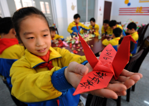 2015年12月31日，河北省邢台市南和县新区小学学生马佳欣展示寄语2016的纸鹤，迎接新年的到来。