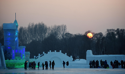 12月31日，在哈尔滨市太阳岛雪博会园区，游客在冰雪建筑前游玩拍照。