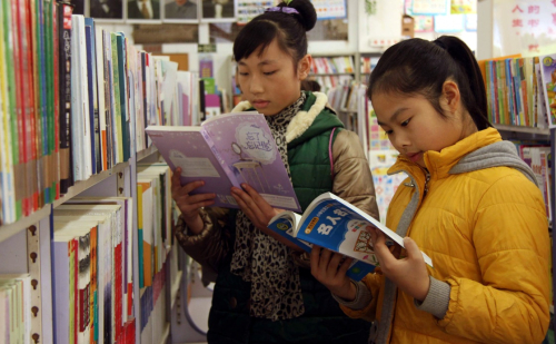 1月1日，两名学生在广西柳州市融水县新华书店看课外读物。新华社发（龙林智 摄）