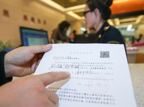 1月7日，企业代表在展示其完善后的先照后证告知书。新华社记者 丁汀 摄