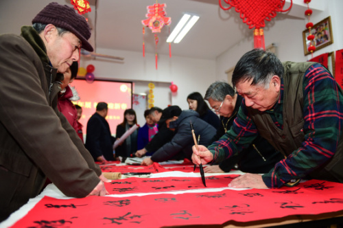 1月8日，书法爱好者为居民义务书写春联。当日，合肥市三里街街道三里一村社区开展“送春联 迎新春”活动。活动中，社区邀请的书法爱好者们义务为居民书写春联、写“福”字，为居民送上新春的祝福。新华社记者 杜宇 摄