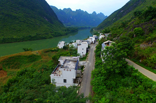 这是广西大化瑶族自治县贡川乡红柳村在实施“整村推进”扶贫开发工作后的新貌（2015年7月5日摄）。目前，广西精准脱贫工作全面展开，抓产业扶贫“换穷业”，抓移民扶贫“挪穷窝”，切实让贫困群众真正得到实惠，预计2015年有85万人实现脱贫。今后5年前三年每年实现脱贫120万人，第四年脱贫93万人，第五年进一步巩固提高，稳定实现全部脱贫。新华社记者 黄孝邦 摄