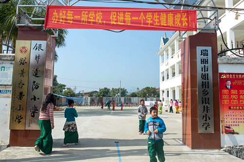 这是1月11日在云南省瑞丽市姐相乡拍摄的银井小学校门。银井小学位于云南省德宏傣族景颇族自治州瑞丽市姐相乡，学生基本都来自中缅两国边境村寨。银井小学现有152名学生，其中缅甸籍学生65名，他们和中国学生一样接受免费义务教育，学习一样的课程。据介绍，银井小学所在的银井村跨越中缅边境，形成了“一寨两国”的奇观。中缅双方边民同宗同族、同语同俗。在这里，通婚互市、走访往来、小学生跨境读书十分平常。新华社记者 胡超 摄