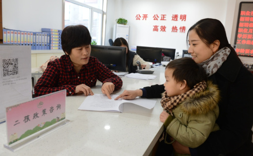 1月14日，在石家庄广源路社区，工作人员（左）为居民介绍“全面二孩”政策。当日，河北石家庄新华区西苑街道办事处开展计生政策培训活动，通过专家讲座、发放宣传资料、解答群众咨询等方式，向群众宣讲普遍关注的“全面二孩”等相关内容，为育龄群众提供便捷的服务。新华社记者 王晓 摄