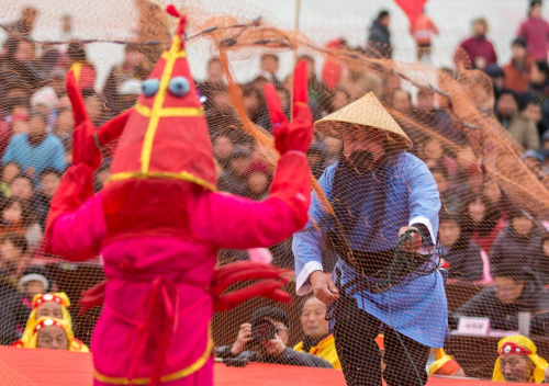 1月14日，在江苏省盱眙县龙虾节广场，当地艺人在进行“捕龙虾”民俗表演。新华社发（周海军 摄）