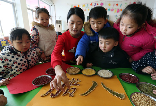 1月15日，山东郯城县郯城街道中心幼儿园的老师指导小朋友制作五谷字画。