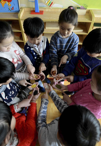 1月15日，山西省长治市小博士国际外国语幼儿园的小朋友展示腊八粥的食材。