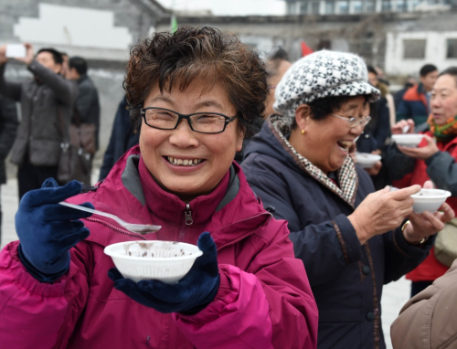 1月16日，五里坨街道社区居民品尝现场熬制的八宝粥。新华社记者 李俊东 摄