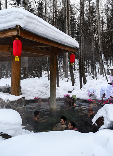 游客在体验长白山冰天雪地中的火山温泉（1月17日摄）。