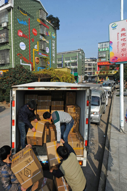 “中国网店第一村——浙江省义乌市青岩刘村的朵熊电子商务公司员工在搬运货物（2015年12月30日摄）。2015年，青岩刘村线上交易额约40亿元。