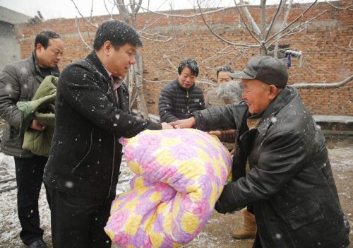 1月22日，河南省平顶山市宝丰县纪检工作人员慰问当地困难群众周朝松（前右）。新华社发（何五昌 摄）