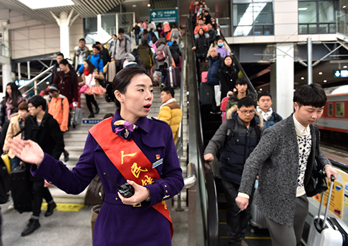 1月23日，福州火车站工作人员在引导旅客进站乘车。