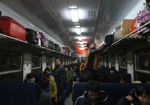 1月23日深夜，旅客在北京开往重庆北的3603次列车上整理行李，列车于1月24日0时11分开出。新华社记者 毛思倩 摄