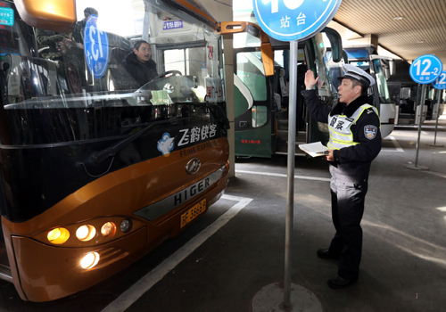 1月24日，民警仲兆毅在检查车辆灯光、雨刮器。当日是2016年全国春运第一天。上海市公安局交警总队防患于未然，向各长途汽车站派出驻站民警，对始发的所有长途汽车车况、驾乘人员证件等进行检查，从源头上遏制因车况不佳等造成的安全事故，确保春运安全有序。新华社记者 凡军 摄