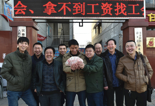 1月26日，在太原市尖草坪区总工会外来务工人员服务中心门口，拿到工资的农民工合影留念。2013年以来，山西省总工会开展“农民工有困难找工会，拿不到工资找工会”专项行动，积极帮助农民工解决欠薪问题。截至2016年1月15日，山西省总工会直接处理工资拖欠案件945起，涉及农民工22454人，追回欠薪15845.88万元，被农民工亲切地称为“娘家人”。