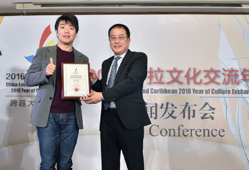 1月26日，文化部外联局副局长朱琦（右）为郎朗颁发“中拉文化交流年形象大使”铭牌。