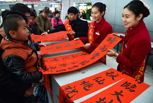 1月27日，在福州火车站，几名铁路工作人员在帮助旅客挑选写好的春联。当日，福州火车站联合客运段、车辆段等单位，组织职工中多名书法爱好者，在车站候车大厅内为旅客义务写春联，给旅客送上新春祝福。