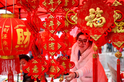 1月28日,一名女孩在湖北省宣恩县李家河镇二虎寨村的集市上挑选春节饰品。新华社发(宋文 摄) 1月28日,一名女孩在湖北省宣恩县李家河镇二虎寨村的集市上挑选春节饰品。新华社发(宋文 摄)