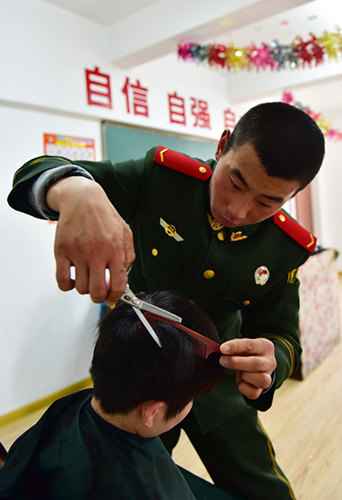 1月29日，武警战士成允鹏给儿童福利院的孩子理发。当日，武警安徽总队第二支队巢湖市中队官兵在巢湖市儿童福利院开展“大手拉小手·献爱迎新春”活动，武警官兵与孩子们互动游戏，帮助他们整理个人卫生，给孩子们带来了食品、玩具、衣服等慰问物品，为孩子们送上一份新春祝福。