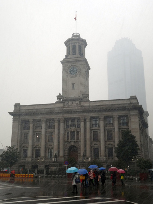 1月31日，市民冒着风雪走过武汉市的标志建筑——武汉关。     当日，湖北多地迎来新一轮雨雪天气。湖北气象部门发布暴雪黄色预警和道路结冰黄色预警，武汉、黄冈、荆州等地有6毫米以上降雪，全省大部分地区将出现对交通有影响的道路结冰。新华社记者 余国庆 摄