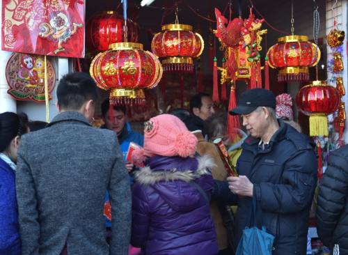 2月7日，市民在北京东城区一家市场选购年画、窗花。当日是农历除夕，北京各大市场供应充足，品种丰富，年节商品供需两旺。新华社记者 罗晓光 摄