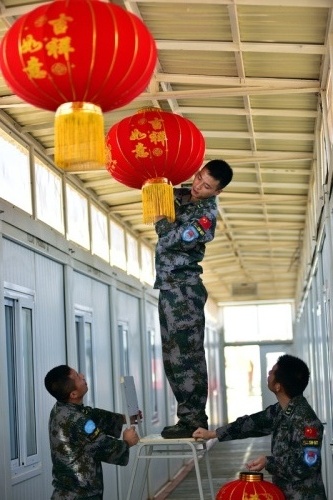 2月4日，在南苏丹首都朱巴，执行国际维和任务的中国维和步兵营战士在营房里挂灯笼。春节到来，正在朱巴执行国际维和任务的中国维和步兵营全体官兵利用休息时间，书写张贴对联，挂灯笼猜灯谜，将营区营造出浓浓的年味。春节期间，官兵们将坚守和平战位，执行难民营警戒、城区巡逻、武装护卫等维和任务，在战位上度过新年。新华社发 付晓飞 摄