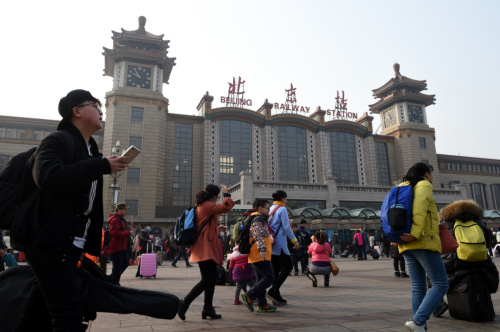 2月12日，在北京火车站，旅客走过站前广场。当日是正月初五，随着春节假期接近尾声，探亲、旅游的人们陆续返程，全国各地迎来返程客流高峰。新华社记者 鞠焕宗 摄