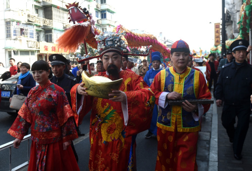 2月12日，“财神”送福队伍在巡游中。当日是大年初五，浙江杭州清河坊举行开市迎“财神”活动，送福队伍在巡游中向开门营业的商户以及市民、游客拜年。新华社记者 韩传号 摄