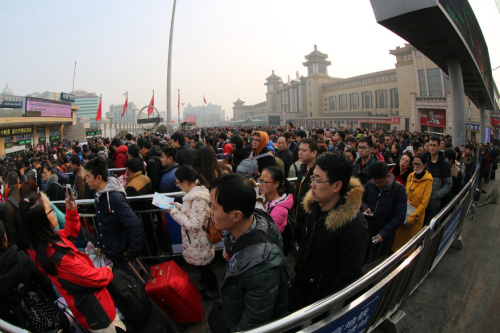 2月12日，旅客在北京站北广场排队等待进入地铁站。新华社发（刘宪国 摄）