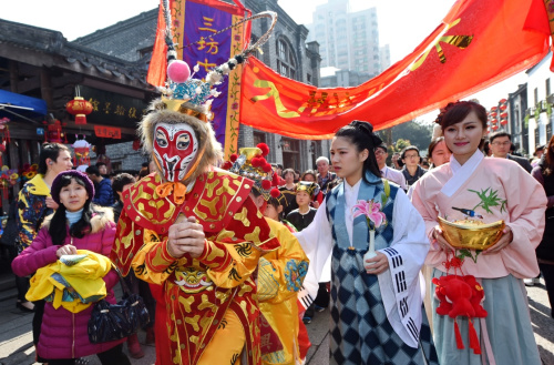 2月12日，由“福建猴王”黄东闽扮演的“大圣”领着五路小财神在福州三坊七巷南后街巡街。新华社记者 林善传 摄