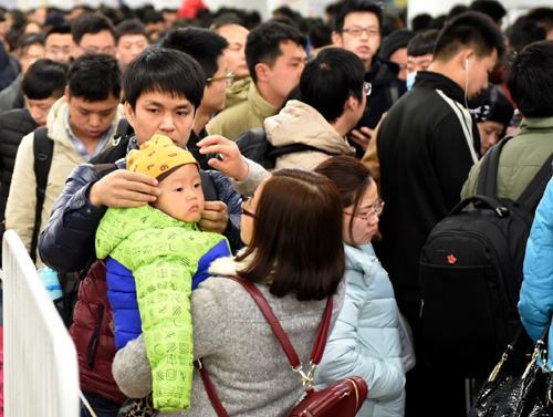 2月13日，在北京西站，一对父母带着孩子一同返京。新华社记者 张晨霖 摄
