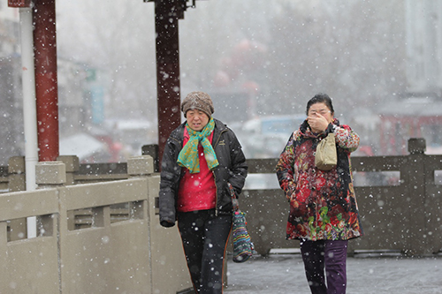 2月14日，青岛市民冒雪出行。2月11日至14日，受寒潮影响，我国中东部地区大风降温和雨雪天气持续。中央气象台14日18时继续发布寒潮黄色预警。