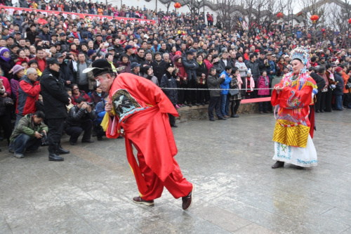 2月12日，游客在山东烟台毓璜顶公园欣赏“龙口秧歌”表演。据国家旅游局统计，今年春节假日期间，全国共接待游客3.02亿人次，比上年同期增长15.6%；实现旅游收入3651亿元。新华社发（申吉忠 摄）